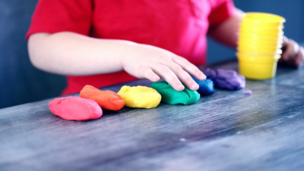 Enfant qui joue avec de la pate a modeler